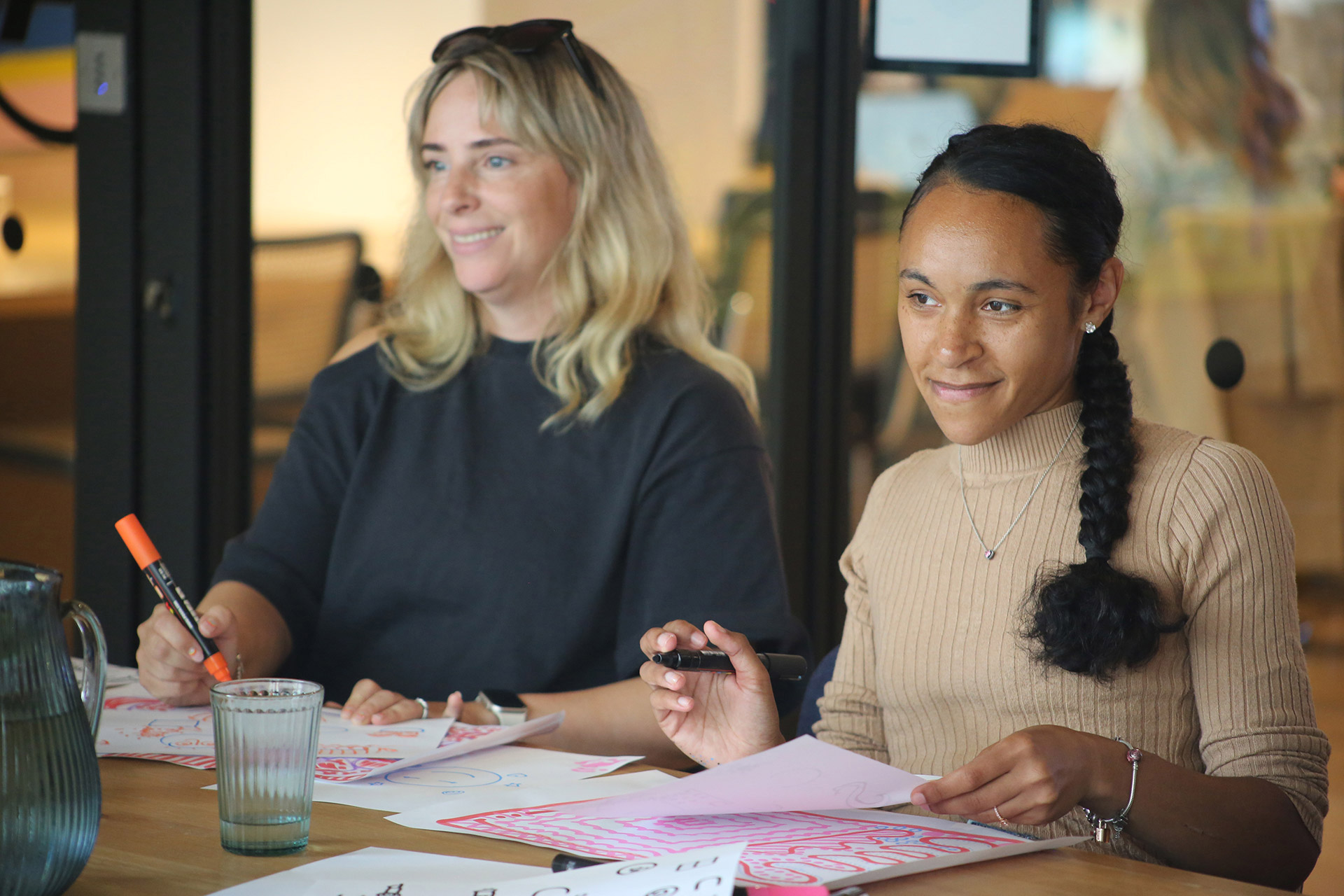 Tow women smiling as they join in a doodle workshop