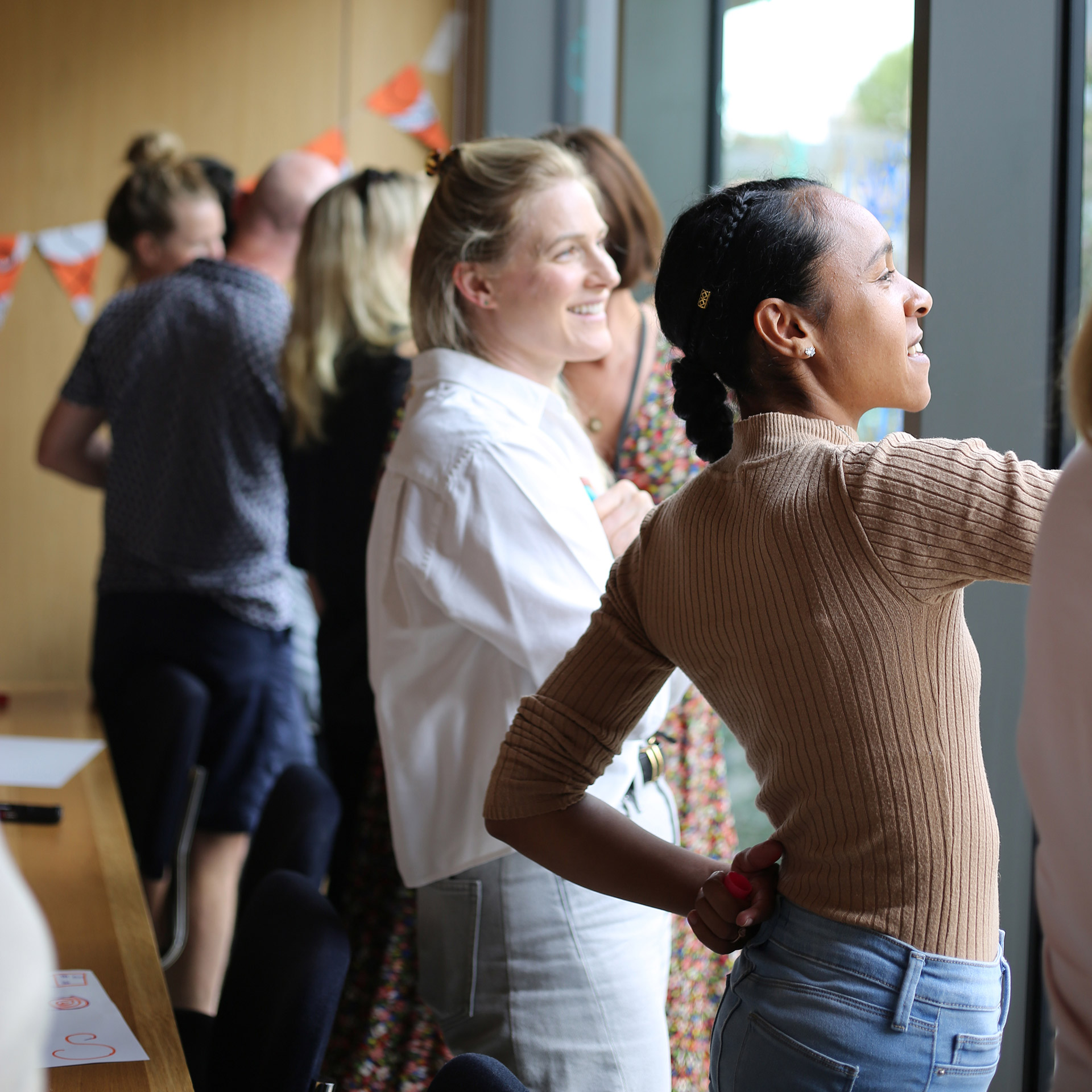 Doodle workshop participants smile as they draw on windows